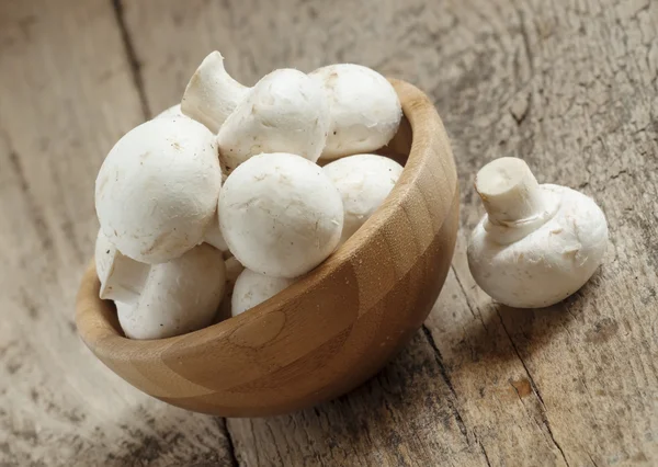 Белые грибы в миске на деревянном столе — стоковое фото
