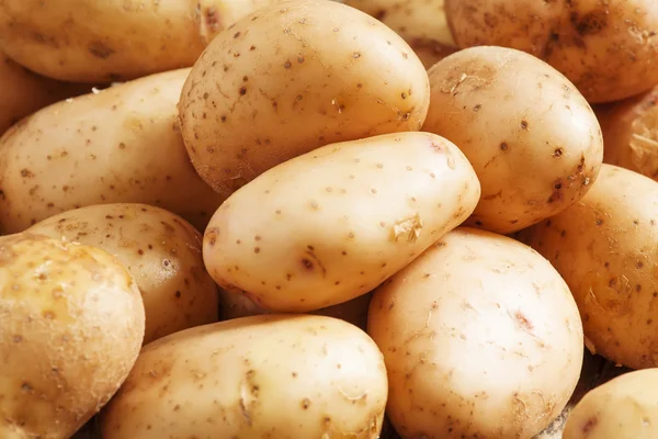 Verse aardappelen op een oud houten tafel — Stockfoto