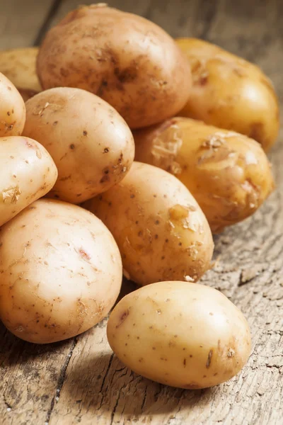 Verse aardappelen op een oud houten tafel — Stockfoto