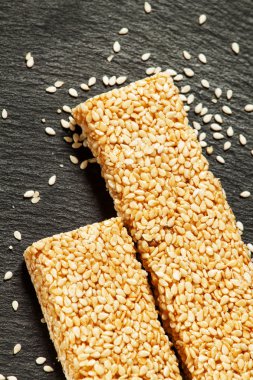 Bar of sesame seeds in honey and scattered grain  clipart