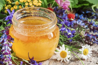 Bal ve ahşap bir masa üzerinde otlar