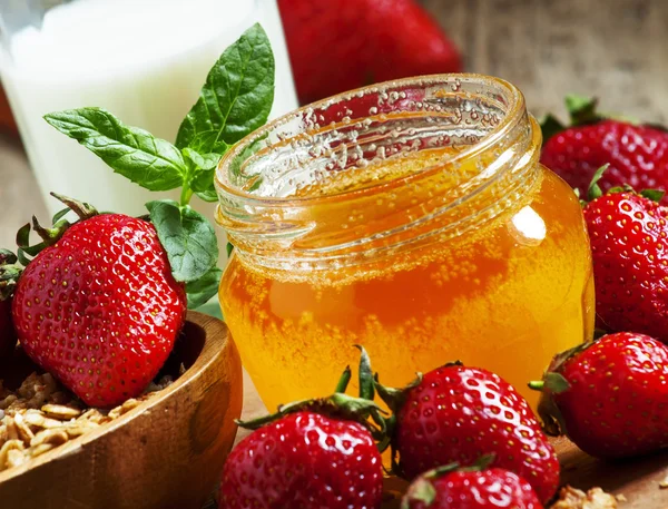 Jar of honey, strawberries, muesli, milk bottle