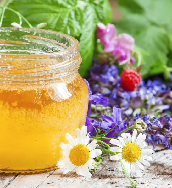 Med a bylinky na dřevěný stůl — Stock fotografie