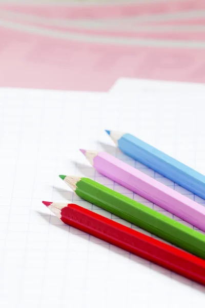 Caderno escolar rosa na caixa e lápis de cor — Fotografia de Stock