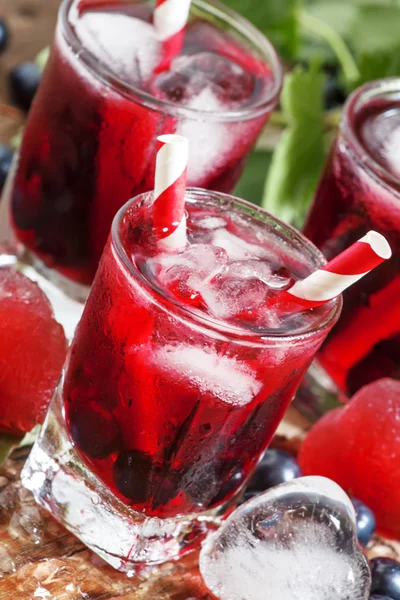 Свежий напиток из черной смородины с ягодами и льдом в форме сердца — стоковое фото