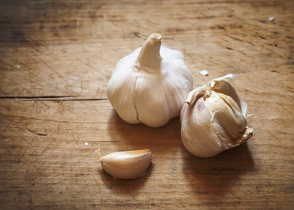 Roher Knoblauch auf einem Holzbrett — Stockfoto