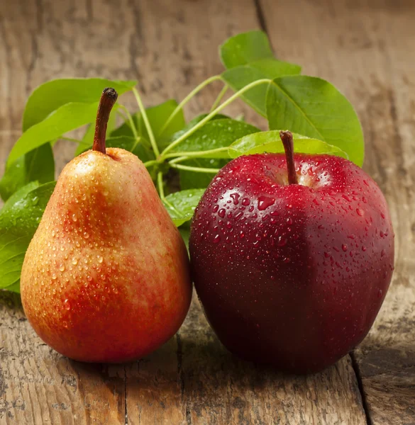 Roter Apfel und gelbe Birne — Stockfoto