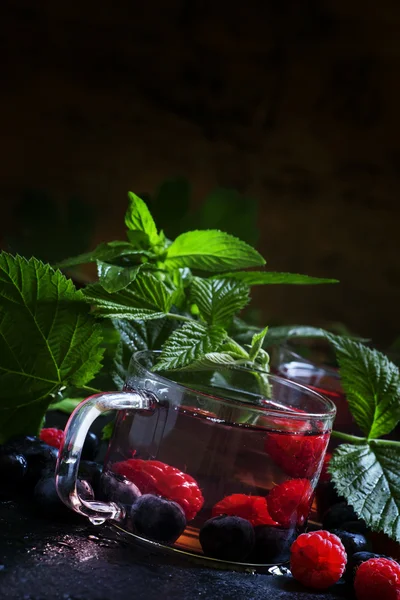 Kalter grüner Tee mit Waldbeeren und Blättern — Stockfoto