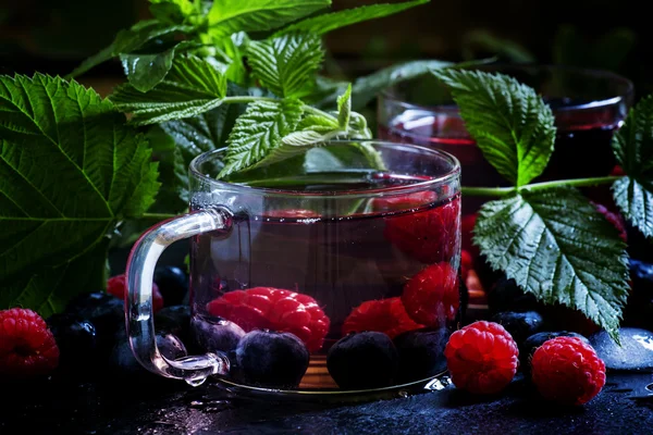 Cold green tea with forest berries and leaves — Stock Photo, Image