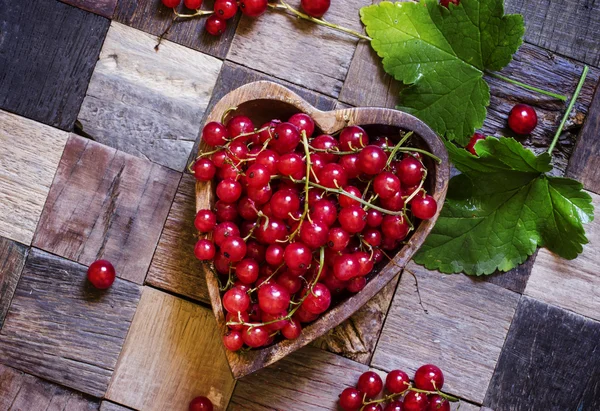 Rode aalbessen in kom in de vorm van het hart — Stockfoto