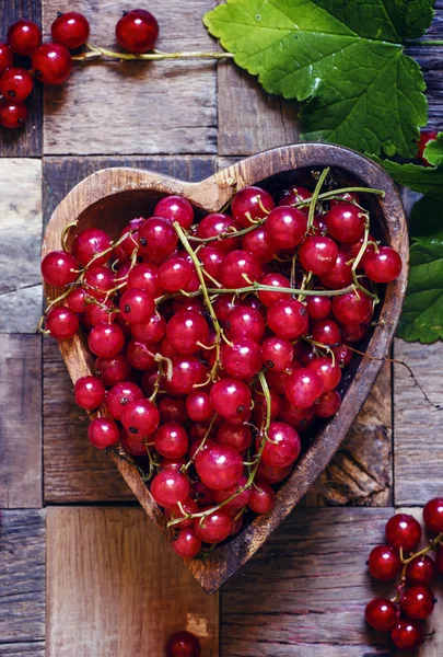 Grosellas rojas en tazón en forma de corazón —  Fotos de Stock