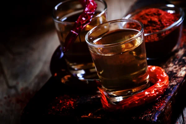 Vodka de pimienta, fondo de madera vintage oscuro — Foto de Stock