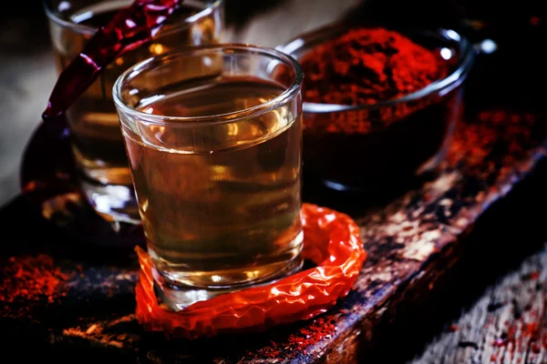 Paprika vodka, tmavě vinobraní dřevěné pozadí — Stock fotografie