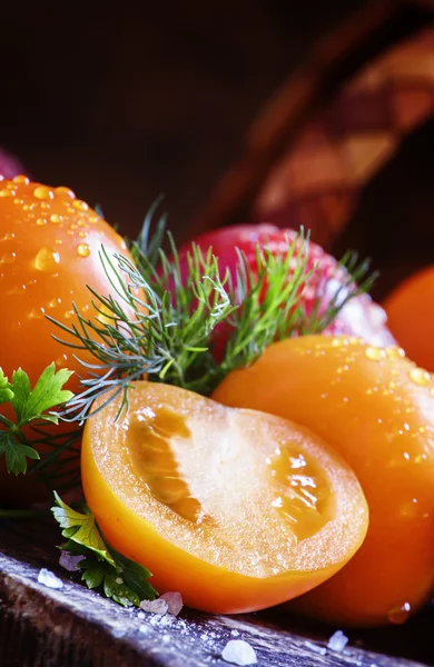 Tomates enteros y cortados de naranja —  Fotos de Stock