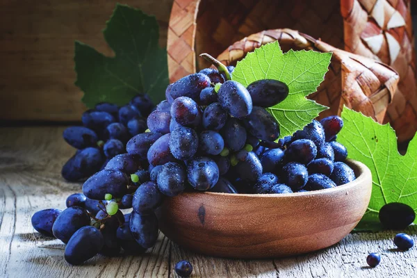 Uvas azuis frescas maduras no fundo de madeira vintage — Fotografia de Stock