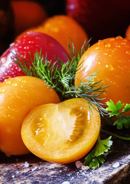 Tomates anaranjados sobre fondo oscuro —  Fotos de Stock