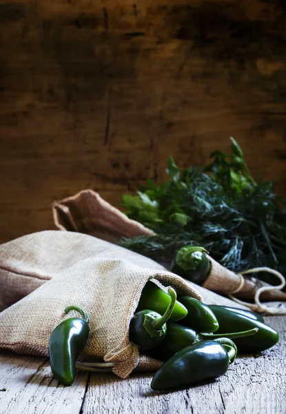 Pittige groene paprika's op een tafel in een doek zakken — Stockfoto