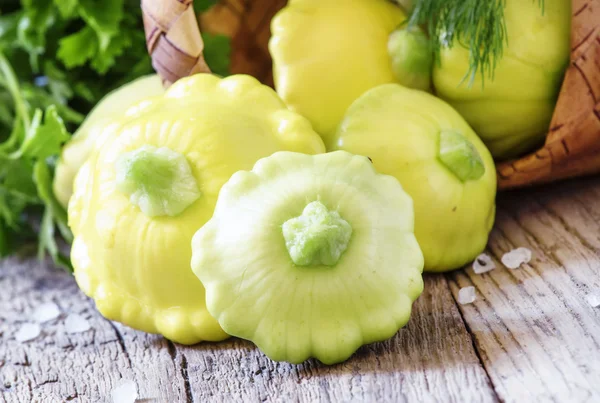 Pequeñas calabazas amarillas esparcidas sobre una vieja mesa de madera — Foto de Stock