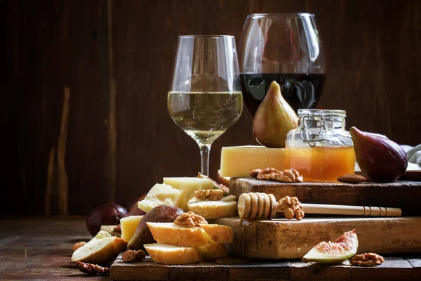 Vinho branco e tinto, queijo, figos, nozes, mel e pão — Fotografia de Stock