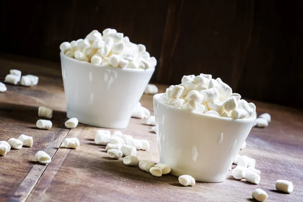 Small marshmallows in white porcelain bowls