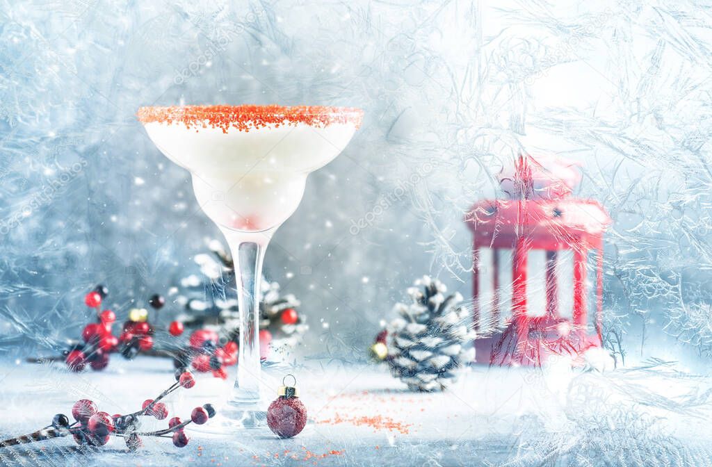 White margarita, Christmas or New Year's winter alcoholic cocktail with rum, coconut and irish cream with red decor iview through a frozen window