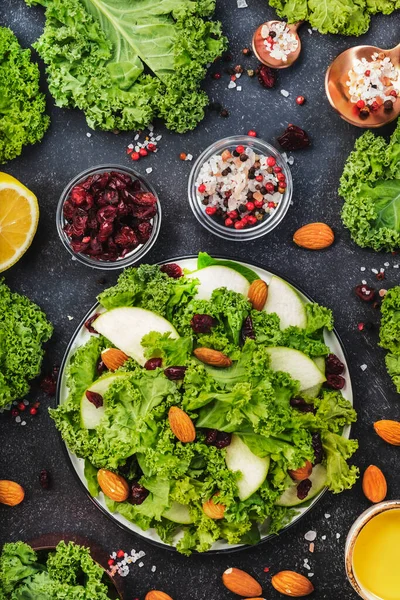 Vegan Kale salad with dried cranberry, apples and almonds. Healthy food, top view, black kitchen table — Stock Image Vegan Kale Salad Dried Cranberry Apples Almonds Healthy Food Top Stock Picture