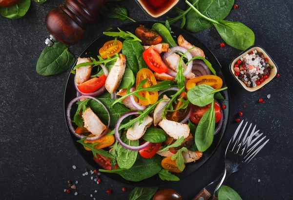 ほうれん草と新鮮なサラダ チキン トマト アルグラ コーンレタスと玉ねぎ 健康食品 黒テーブル — ストック写真