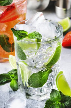 Taze mojito mocktail seti, kireç, nane, çilek ve gri arka planda buzlu buzlu. Alkollü ya da alkolsüz içecekler, içecekler ve kokteyller.