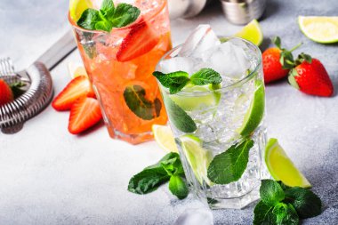 Taze mojito mocktail seti, kireç, nane, çilek ve gri arka planda buzlu buzlu. Alkollü ya da alkolsüz içecekler, içecekler ve kokteyller.