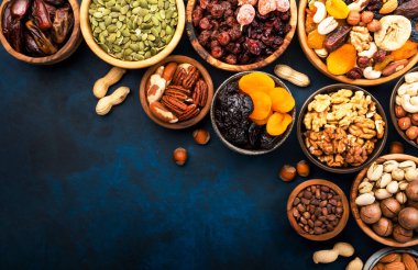 Fındık ve kurutulmuş meyve. Kurutulmuş kayısı, incir, kuru erik, kuru üzüm, kızılcık, ceviz, fıstık, fıstık, fındık, badem ve diğerleri. Gıda arka planı, üst görünüm