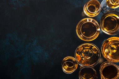 Sert alkollü içecekler, bardaklarda alkol ve damıtma: votka, konyak, tekila, viski, brendi ve viski, grappa, vermut, rom. Mavi arkaplan, üst görünüm