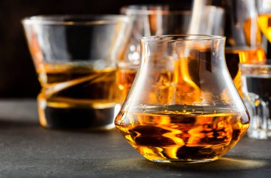 Sert alkollü içecekler ve çeşitli bardaklarda damıtılıyor: votka, konyak, tekila, viski, brendi ve viski, grappa, likör, vermut, tentür, rom. Kahverengi arkaplan