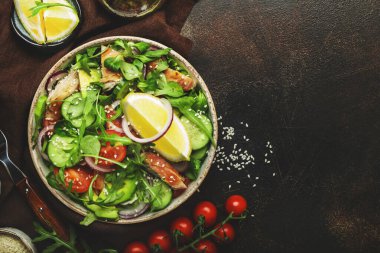 Kızarmış tavuklu taze salata, kiraz domatesleri, roka, kırmızı soğan, avokado, susam tohumu ve limon yağı sosu. Sağlıklı gıda konsepti. Üst Manzara. Boşluğu kopyala