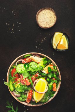 Kızarmış tavuklu taze salata, kiraz domatesleri, roka, kırmızı soğan, avokado, susam tohumu ve limon yağı sosu. Sağlıklı gıda konsepti. Üst Manzara. Boşluğu kopyala