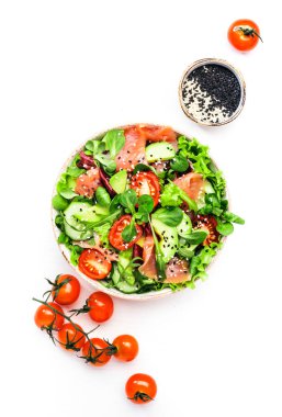 Taze salata ile tuzlanmış somon, avokado, salatalık, susam tohumu, zeytinyağı, domates ve karışık otlar. Beyaz arkaplan, üst görünüm, kopyalama alanı