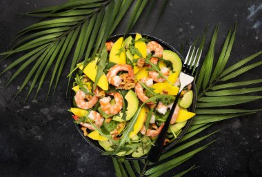 Karides, mango ve cevizli Avokado salatası, ıspanak ve Arugula. Sağlıklı beslenme konsepti Üst görünüm, gri arkaplan