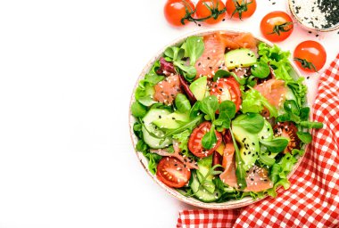 Taze salata ile tuzlanmış somon, avokado, salatalık, susam tohumu, zeytinyağı, domates ve karışık otlar. Beyaz arkaplan, üst görünüm, kopyalama alanı