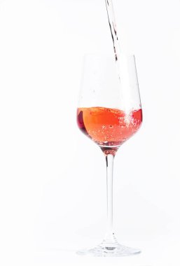 Şişeden gül şarabı dökülüyor, beyaz fırında. Rosado, rosato ya da şarap tadımı, bar konsepti. Boşluğu Kopyala