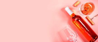 Pembe fırında şişeli gül şarabı kadehi. Rosado, rosato ya da kırmızı şarap tatma. Boşluğu kopyala, üst görünüm