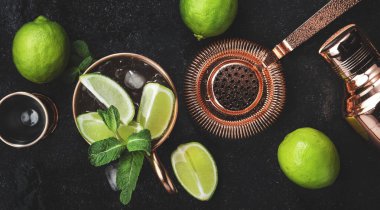 Moskova Katırı. Zencefilli bira, votka, limon ve buzlu kokteyl. Bakır bar aletleri. Siyah bar tezgahı. Üst görünüm