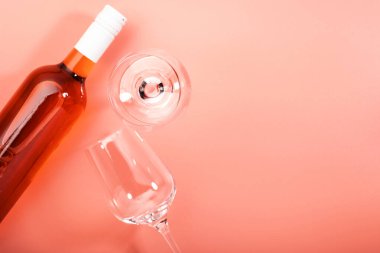 Pembe fırında şişeli gül şarabı kadehi. Rosado, rosato ya da kırmızı şarap tatma. Boşluğu kopyala, üst görünüm