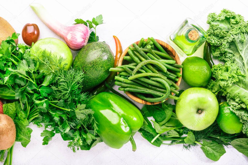 Green vegetables, herbs, beans and fruits. Healthy clean eating: leaf vegetables, seeds, superfoods on white background, vegetarian protein source and detox diet nutrition