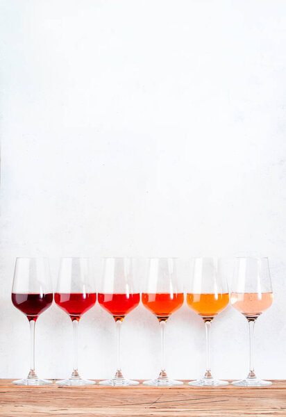 Rose wine glasses set on wine tasting. Different varieties, colors and shades of pink wines on white background