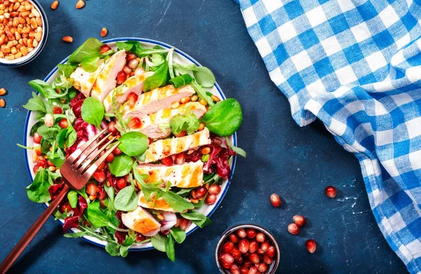 焼きチキンと新鮮なサラダ ほうれん草 アルグラ 杉の実とザクロ 健康食品 食事やケトの食事の概念 最上階だ 青いテーブル — ストック写真