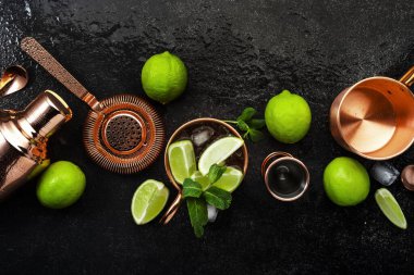 Moskova Katırı. Zencefilli bira, votka, limon ve buzlu kokteyl. Bakır bar aletleri. Siyah bar tezgahı. Üst görünüm