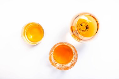 Sert alkollü içecekler, bardaklarda alkol ve damıtma: votka, konyak, viski, viski ve diğer şeyler. Beyaz arka plan. Sert ışık