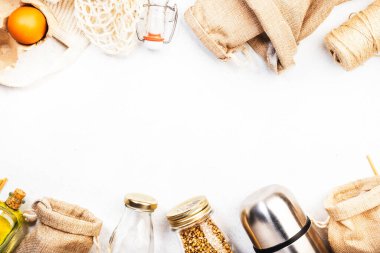 Geri dönüşümlü, yeniden kullanılabilir çevre dostu çantalar, paket, şişe, kutu ve konteynırlar, ağ torbası. Beyaz arka plan, üst manzara. Sıfır atık, plastiksiz ve sürdürülebilir yaşam tarzı kavramı