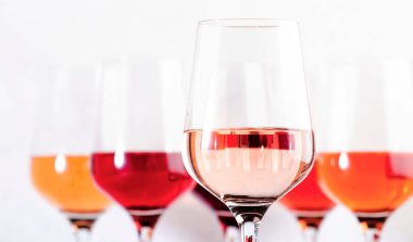 Rose wine glasses set on wine tasting. Different varieties, colors and shades of pink wines on white background clipart