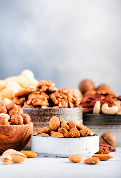 Assortment of nuts. Cashews, hazelnuts, walnuts, almonds etc. Healthy Food Snacks mix on gray background, copy space