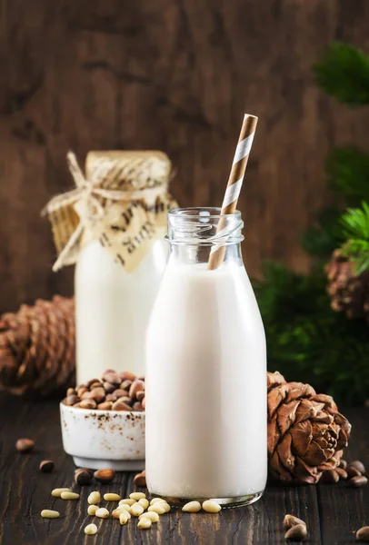 Cedernotenmelk Flessen Houten Ondergrond Niet Zuivel Alternatieve Veganistische Melk Dennenappels — Stockfoto